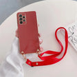 Red smartphone with a multiple-lens camera and an attached red lanyard.