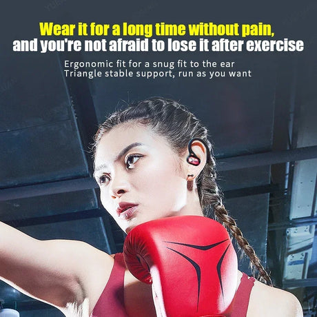 Red wireless earbud worn by a woman with braided hair in athletic attire.