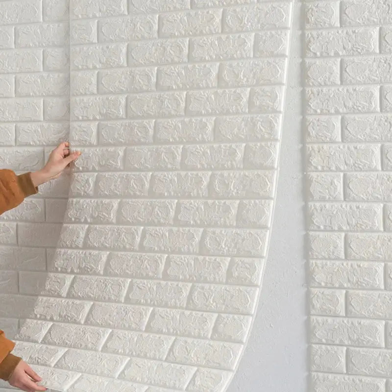a woman is painting a brick wall