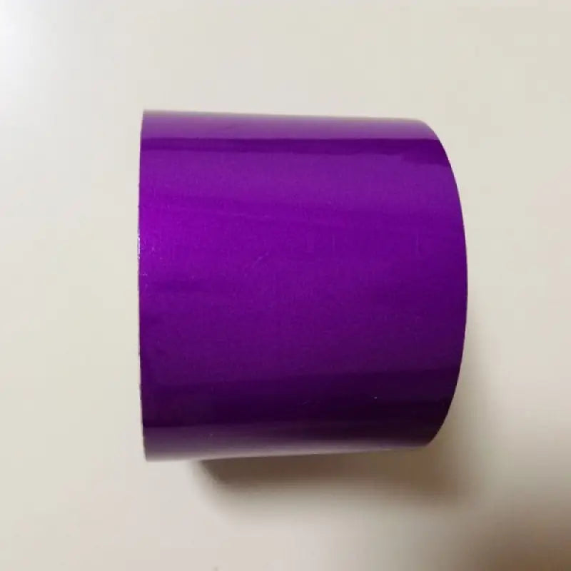 a purple roll of tape on a white surface
