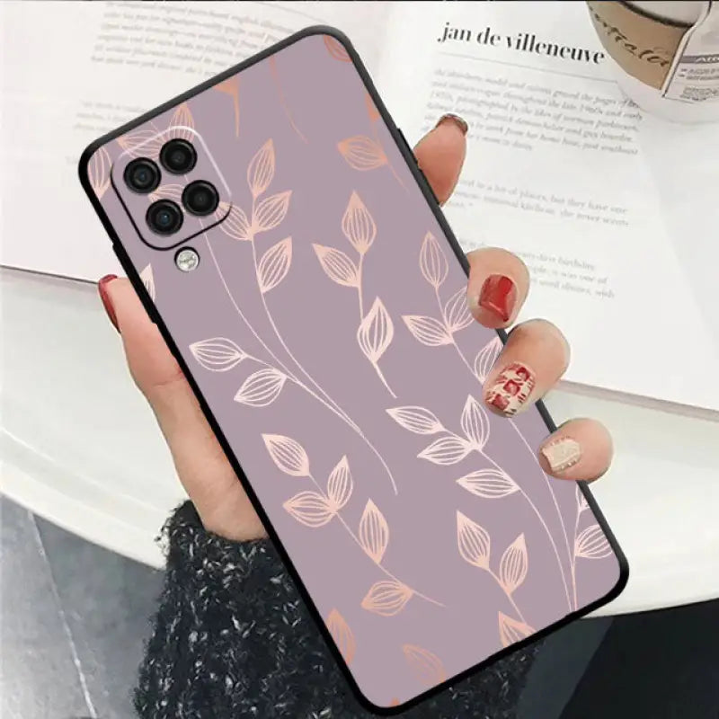 a woman holding a phone case with a pink flower pattern