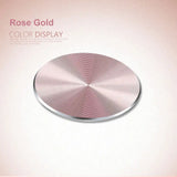 a pink colored background with a circular metal plate