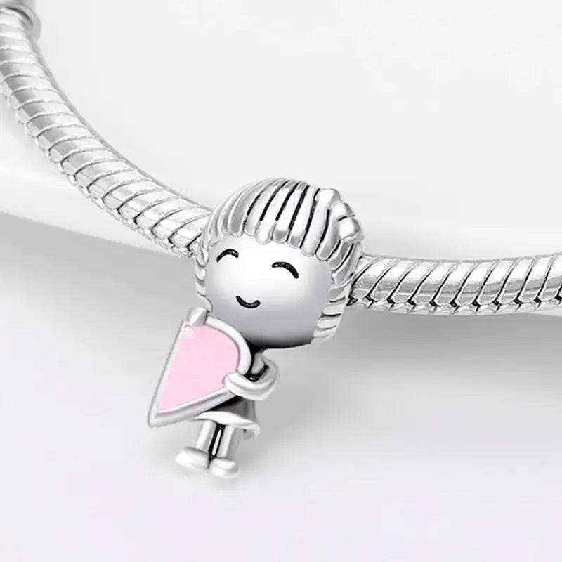 a silver bracelet with a little girl holding a pink heart