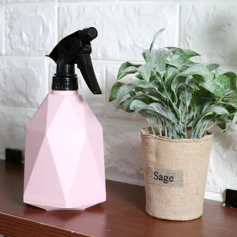 a pink spray bottle sitting on top of a wooden table next to a plant