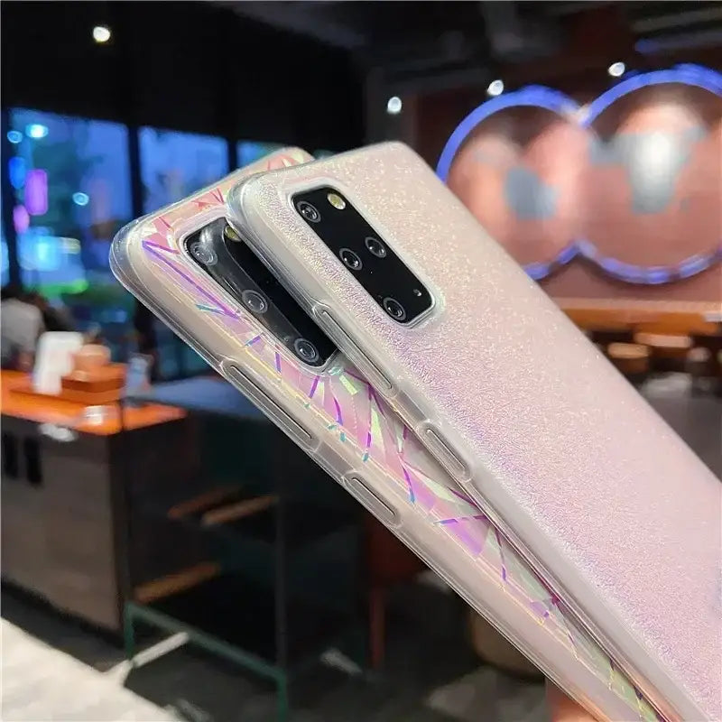 someone holding a samsung galaxy s10e with a pink holographic design