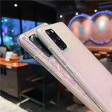 Someone holding a samsung galaxy s10e with a pink holographic design