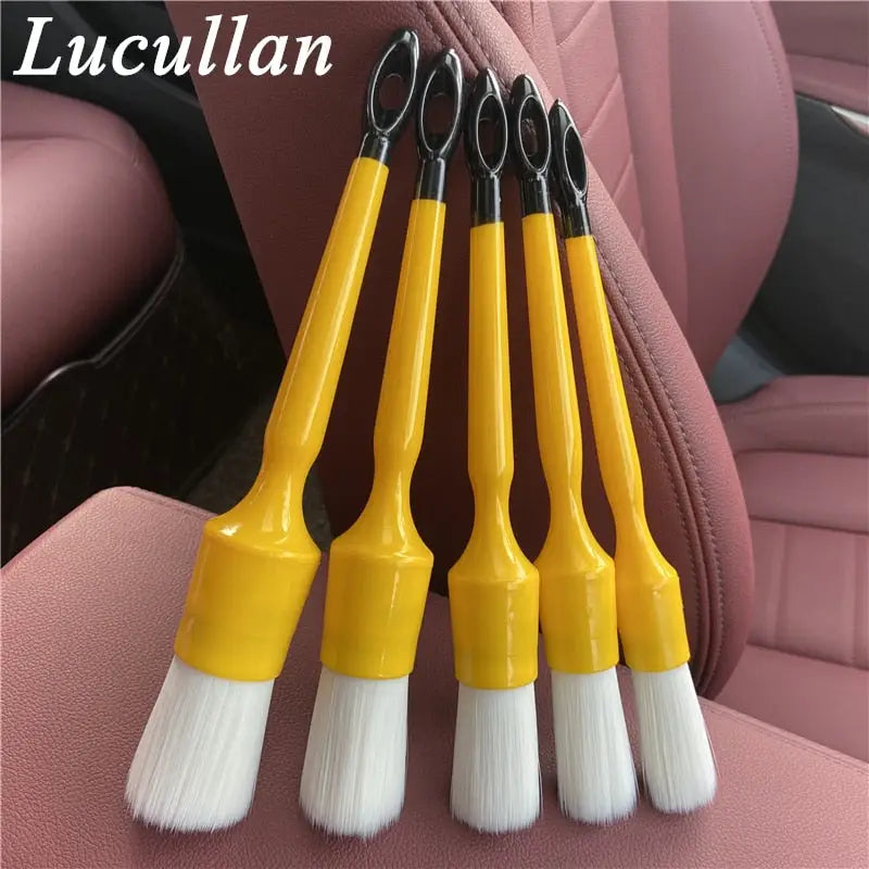 four yellow and white brushes sitting on top of a car seat
