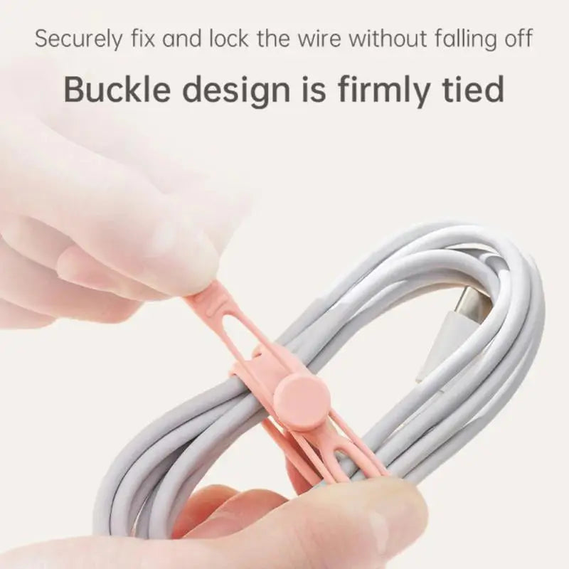 a hand holding a cable with a pink cord
