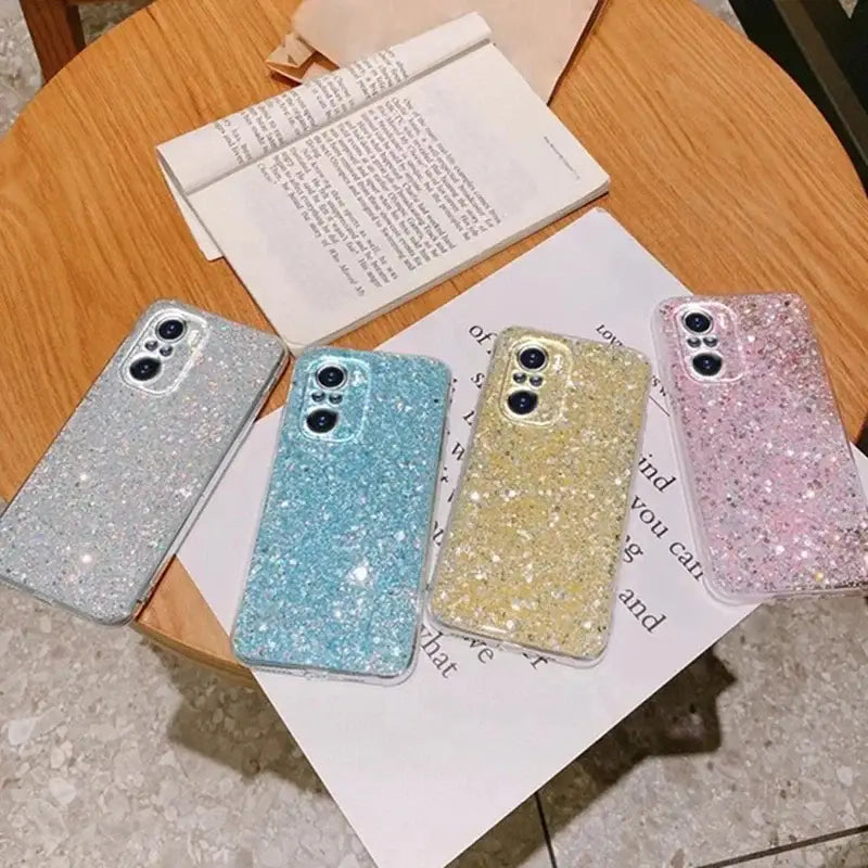 a set of three glitter iphone cases on a table