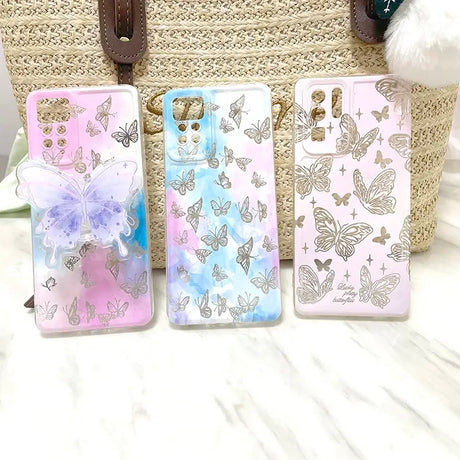 A set of three phone cases with butterflies on them