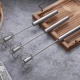 a set of three stainless cheese tools on a wooden cutting board