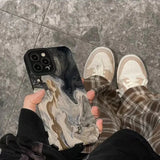 a person holding a phone with a marble pattern on it
