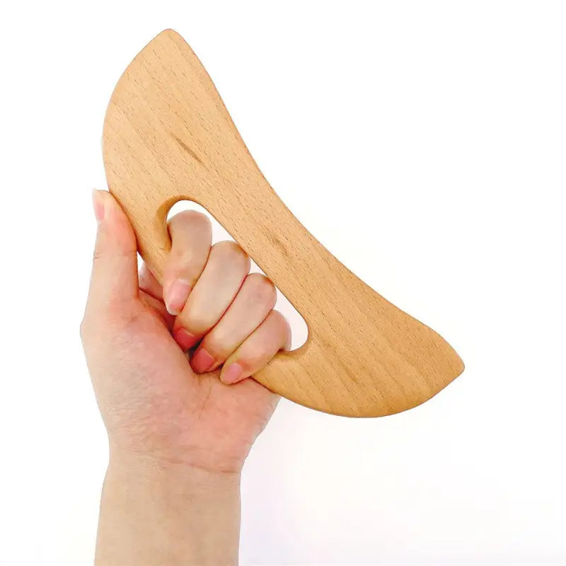 a hand holding a wooden heart