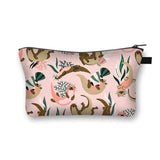 a pink and brown pouch bag with a pattern of birds and flowers