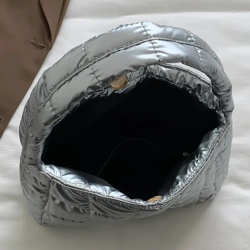 a silver bag sitting on top of a bed