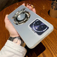 Silver smartphone case with an integrated ring stand and a camera lens protector.