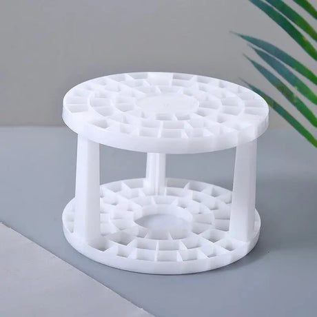 a white plastic table with a plant in the background