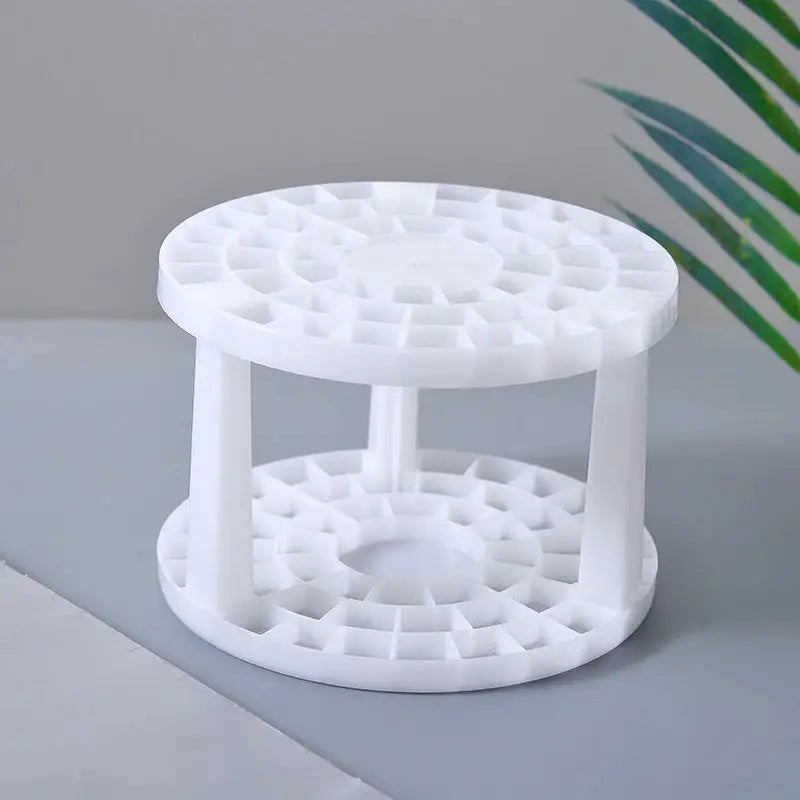 a white plastic table with a plant in the background