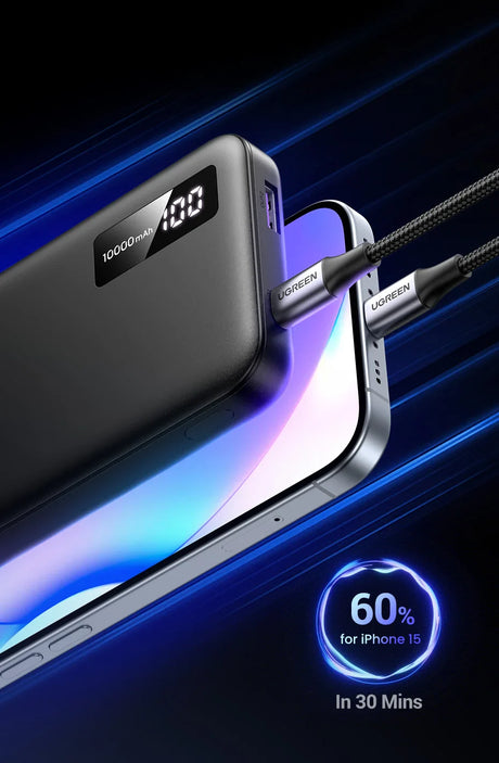 Sleek black power bank with digital display showing ’100’’ and connected to a smartphone.