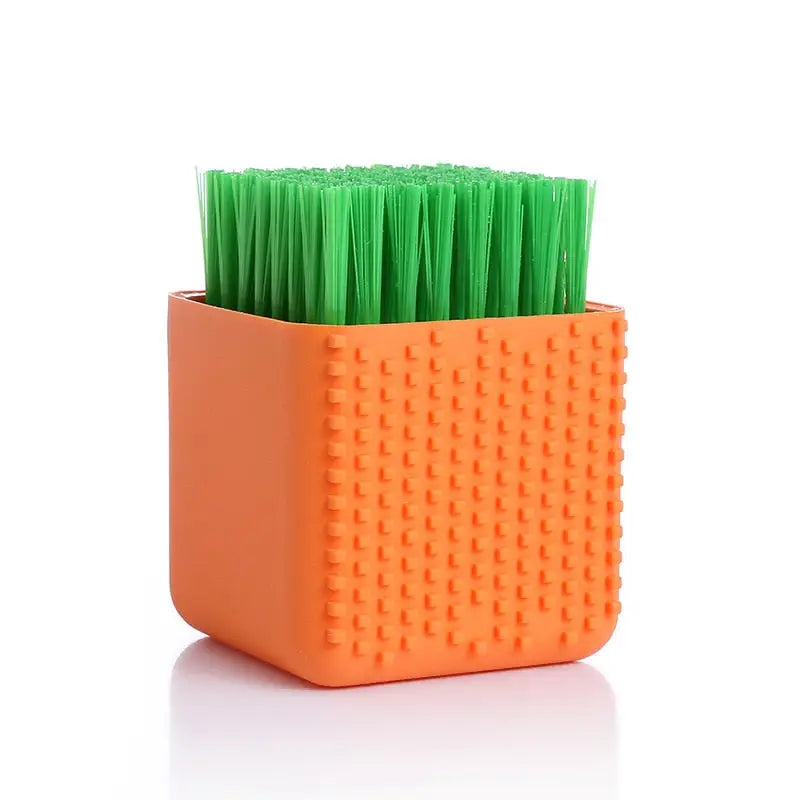 a small orange plastic toothbrush with green toothbrushs