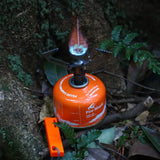 a small orange gas stove sitting on the ground