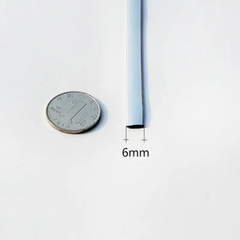 a close up of a quarter of a coin next to a thin metal tube