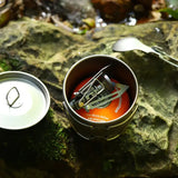 a small tin with a candle and a teaspe