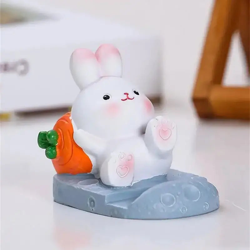 a small toy rabbit holding a carrot