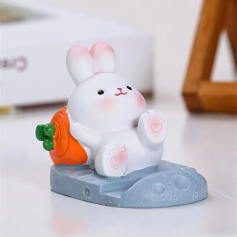 a small white rabbit holding a carrot