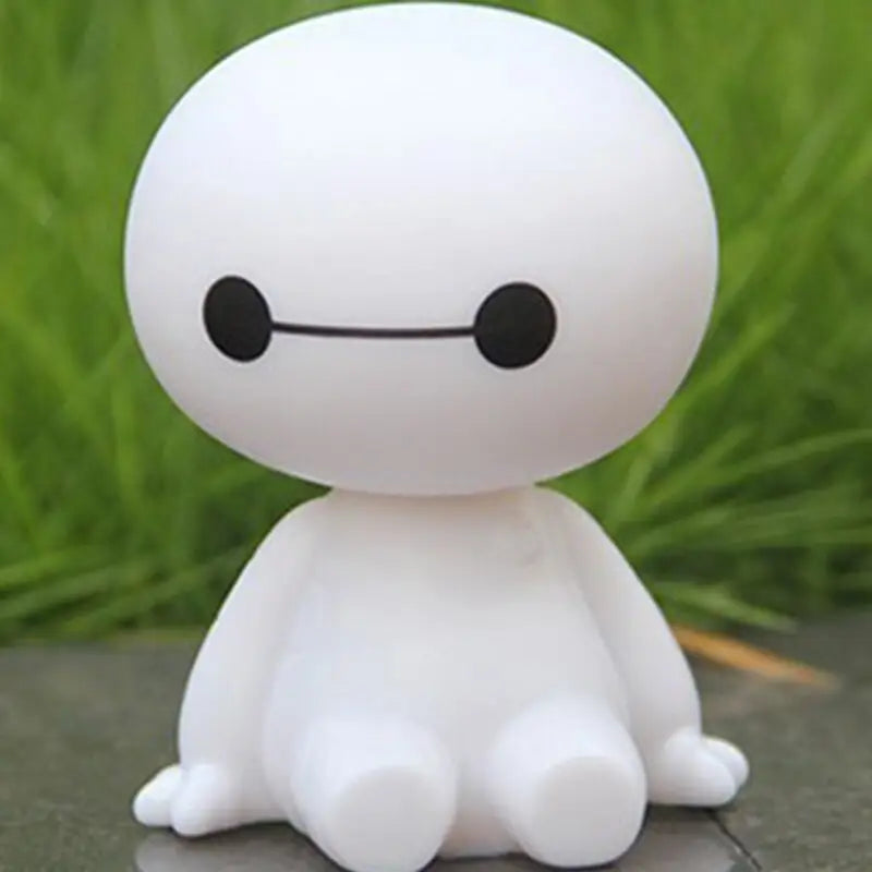 a small white toy sitting on a rock