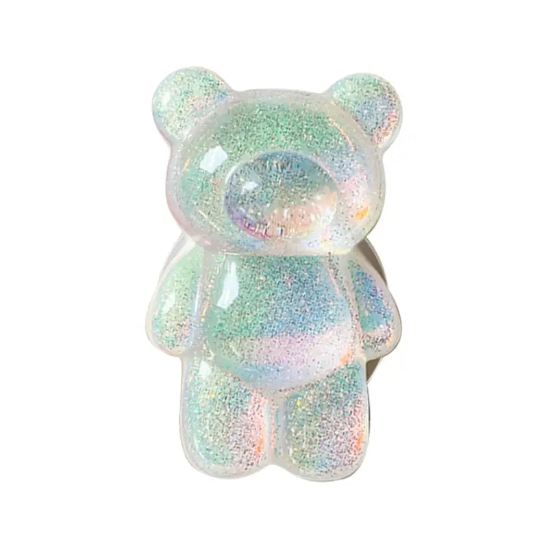 a small white teddy bear with a green and blue glitter coating