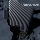 A smartphone with a black carbon fiber textured case featuring multiple camera lenses and ’SHOCKPROOF’ text.
