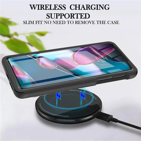 A smartphone in a black protective case, wirelessly charging on a round pad.