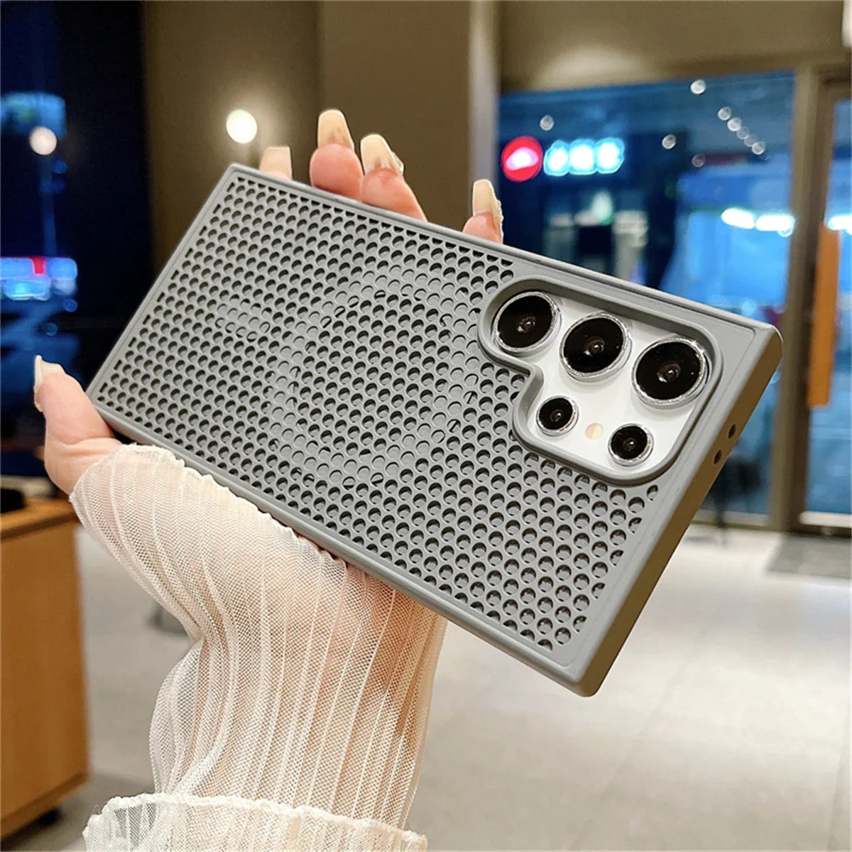 Smartphone case with a perforated metal design and multiple camera cutouts.