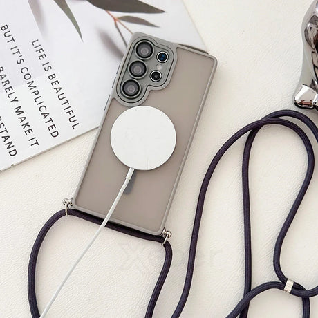 Smartphone in a gray case with a lanyard and a wireless charger.