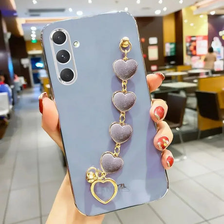 Smartphone with a lavender case and heart-shaped charm accessory attached.