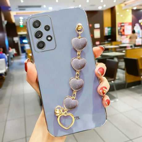 Smartphone with a lavender case and heart-shaped charm accessory attached.