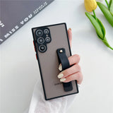 A smartphone in a matte brown case with a black strap holder and prominent camera lenses.