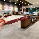 A smartphone with a pink protective case.
