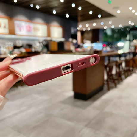 A smartphone with a pink protective case.