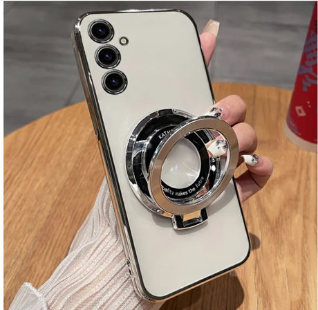 Smartphone with three cameras and a circular metal ring attachment on its back.