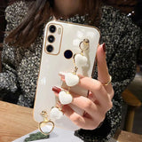 Smartphone with a white case and a decorative heart-shaped charm attached.