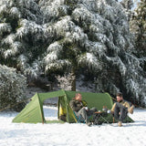 two people sitting in the snow next to a tent