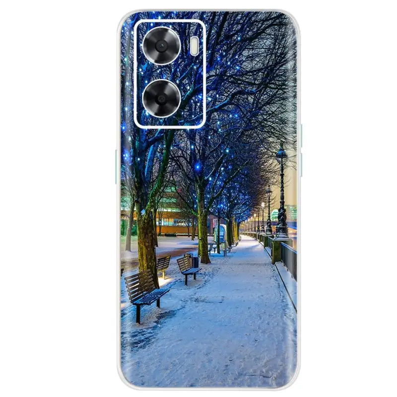 a snowy night in the city with a bench and trees on the sidewalk phone case