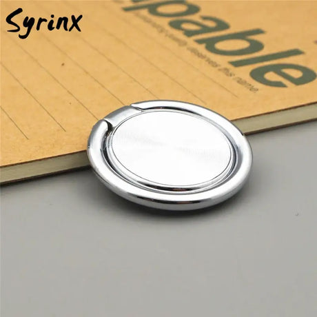 a round metal button with a white background