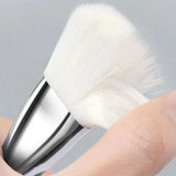 a hand holding a brush with a white handle