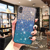 Sparkly blue and silver gradient phone case with rhinestones held by a hand with black nail polish.