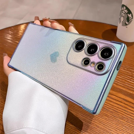 A sparkly, iridescent phone case with a heart accent and clear camera lens cutouts.