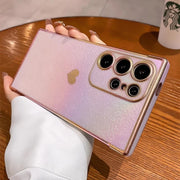 Sparkly, iridescent smartphone case with a gold heart design and camera protection.