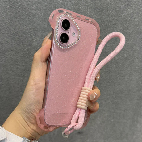 Sparkly pink iPhone case with a rhinestone camera frame and attached wrist strap.